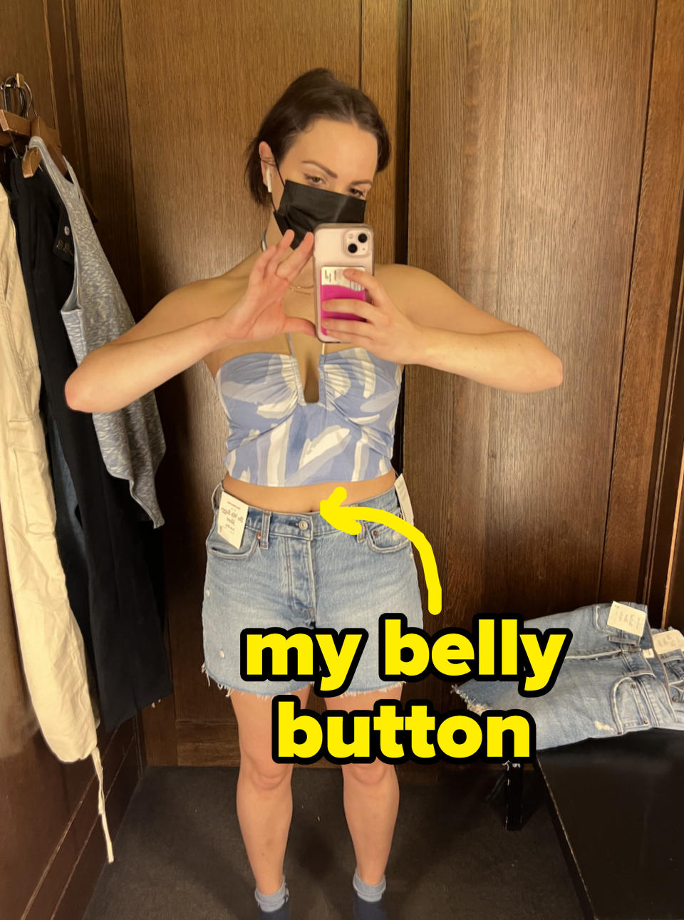 Hannah in a sleeveless top and jean short with arrow pointing to midriff, with text "my belly button"