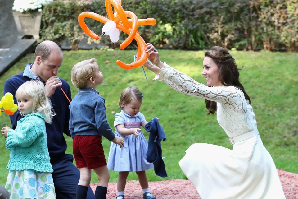 <p>The Duchess plays with balloon animals on the grass with Prince William, Prince George, and Princess Charlotte while at a party for military families during a royal tour of <a href="https://www.harpersbazaar.com/fashion/street-style/g7897/kate-middleton-royal-canada-tour-fashion/" rel="nofollow noopener" target="_blank" data-ylk="slk:Canada;elm:context_link;itc:0;sec:content-canvas" class="link ">Canada</a>.</p>