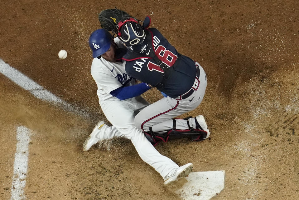 Los Angeles Dodgers' Max Muncy scores past Atlanta Braves catcher Travis d'Arnaud on a single by Will Smith during the third inning in Game 7 of a baseball National League Championship Series Sunday, Oct. 18, 2020, in Arlington, Texas. (AP Photo/David J. Phillip)