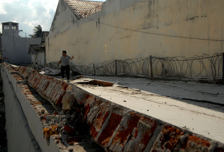 An officer walks at a collapsed prison following an earthquake in Palu, Central Sulawesi, Indonesia, October 2, 2018 in this photo taken by Antara Foto. Antara Foto/Abriawan Abhe/ via REUTERS