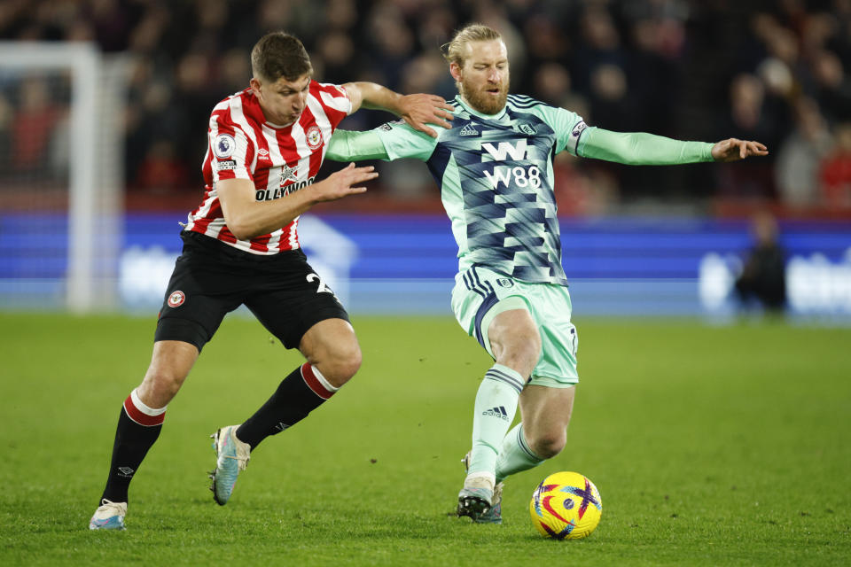 Brentford's Vitaly Janelt, left, battles for the ball with Fulham's Tim Ream, right, during the English Premier League soccer match between Brentford and Fulham at Brentford Community Stadium in Brentford, West London, Monday, March 6, 2023. (AP Photo/David Cliff)