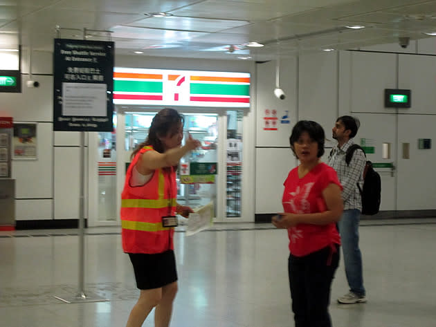 A "goodwill ambassador" assists a commuter with directions to her destination. (Yahoo! photo/Jeanette Tan)