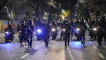 Police gesture outside Congress after the Senate approved a reform bill presented by Argentine President Javier Milei in Buenos Aires, Argentina, Wednesday, June 12, 2024. The bill must now be debated article-by-article before being sent to the Lower House. (AP Photo/Rodrigo Abd)