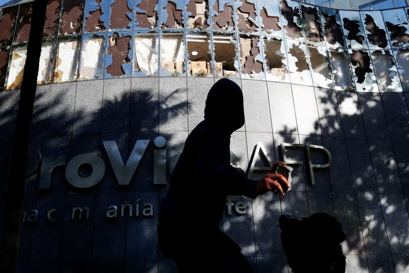 Foto de archivo. Un manifestante arroja una piedra a un edificio de la Administradora de Fondos de Pensiones de Chile (AFP) Provida durante una protesta en Providencia, un barrio acomodado, en Santiago