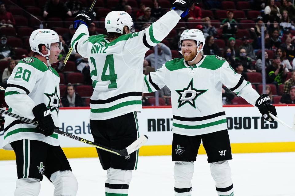 Dallas Stars center Roope Hintz (24) celebrates his goal against the Arizona Coyotes with Stars center Joe Pavelski, right, and Stars defenseman Ryan Suter (20) during the second period of an NHL hockey game Sunday, Feb. 20, 2022, in Glendale, Ariz. (AP Photo/Ross D. Franklin)