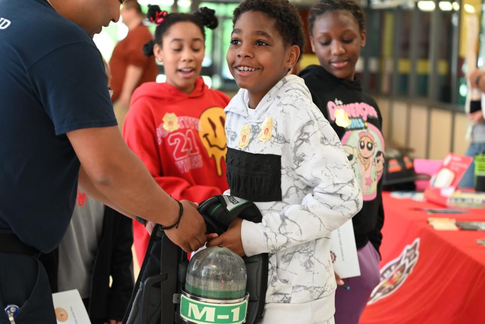 Darden Elementary fifth grader Jayceon picks up the South Bend Fire Department's self-contained breathing apparatus gear on May 10, 2024 at 18645 Janet Drive.