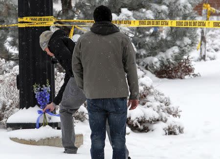 Cody McKone and Joseph Sutherland of Colorado Springs place flowers at an intersection near the Planned Parenthood clinic in Colorado Springs, Colorado November 28, 2015. REUTERS/Isaiah J. Downing