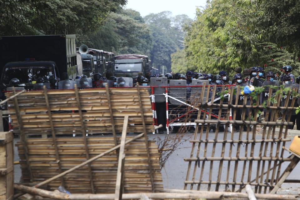 Police forces stand in formation behind a barricade during a security operation in Mandalay, Myanmar, Saturday, Feb. 20, 2021. Two anti-coup protesters were shot dead by riot police who fired live rounds Saturday in Mandalay, Myanmar's second-largest city, local media reported. (AP Photo)