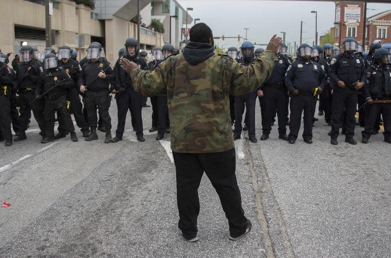 A demonstrator holds up his hands while standing in front of a line of Baltimore Police in riot gear while protesting the death of Freddie Gray, an African American man who died in police custody, in Baltimore, Maryland, April 25, 2015