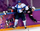 Juuso Hietanen of Finland (38) pins Blake Wheeler of the United States (28) up against the boards during the third period of the men's bronze medal ice hockey game at the 2014 Winter Olympics, Saturday, Feb. 22, 2014, in Sochi, Russia. (AP Photo/Julio Cortez)