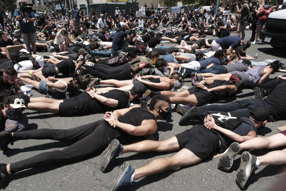 LGBTQ community members join Black Lives Matter demonstrators lie face down depicting George Floyd during his detention by police, blocking an intersection in protest over Floyd's death, in West Hollywood, Calif., on Wednesday, June 3, 2020. Floyd, an African American, died on May 25 after a white Minneapolis police officer pressed a knee into his neck for several minutes even after he stopped moving and pleading for air. (AP Photo/Richard Vogel)