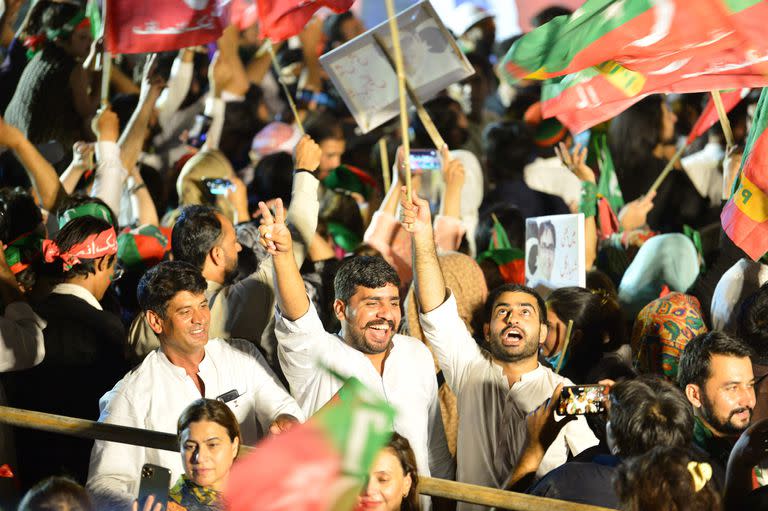 Simpatizantes del ex primer ministro de Pakistán y líder del partido Pakistan Tehreek-e-Insaf (PTI), Imran Khan, agitan banderas durante una manifestación de protesta contra el gobierno en Islamabad el 20 de agosto de 2022.