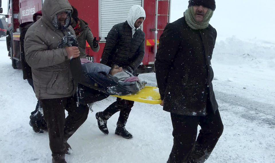 Emergency service members carry a casualty at the site of avalanche near the town of Bahcesehir, in Van province, eastern Turkey, Wednesday, Feb. 5, 2020. Dozens of rescue workers are missing after being hit by an avalanche while on a mission to find two people missing in a previous snow-slide. The emergency services were called to a highway near the mountain-surrounded town in Van province, which borders Iran, after an avalanche struck late Tuesday, burying a snow-clearing vehicle and a minibus.(Yilmaz Sonmez/IHA via AP)