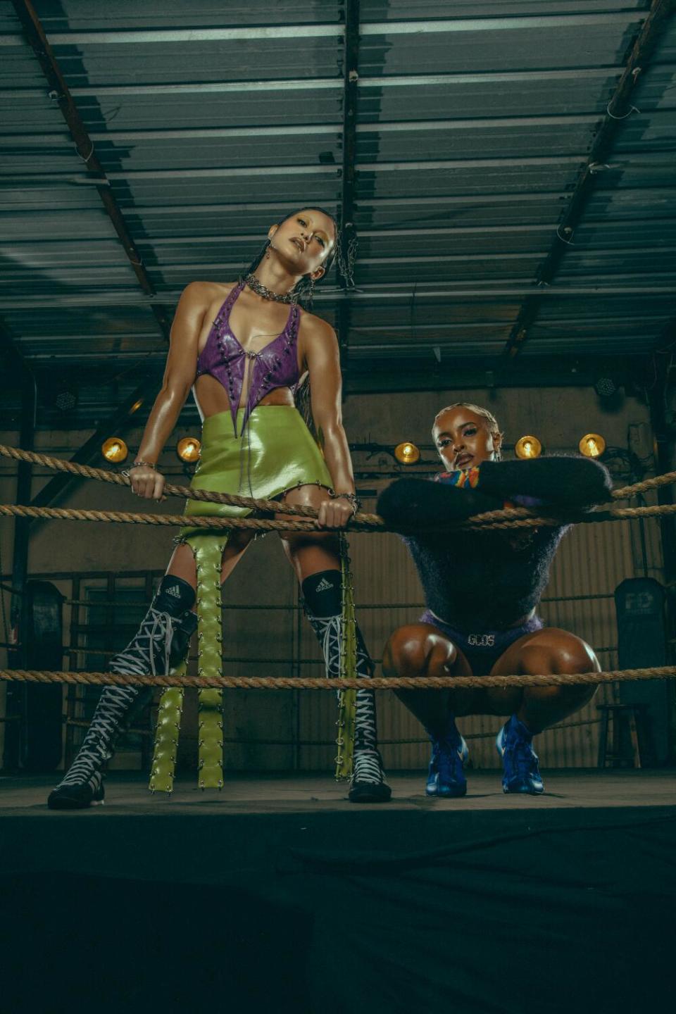 Two boxers pose in the ring.