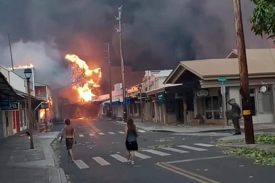 People watch as smoke and flames fill the air from raging wildfires on Front Street in downtown Lahaina, Maui on Tuesday, August, 8, (AP)