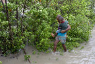 DAKOP, KHULNA, BANGLADESH - 2020/05/20: A man with his son walks through water after crosses the river by boat immediately before Cyclone Amphan hits Bangladesh costal area in Khulna. Authorities have scrambled to evacuate low lying areas in the path of Amphan, which is only the second "super cyclone" to form in the northeastern Indian Ocean since records began. (Photo by K M Asad/LightRocket via Getty Images)
