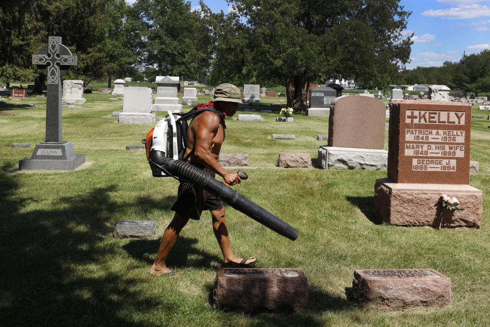 Steve Rodriguez works in the St. Joseph's Cemetery Tuesday, June 15, 2021, in Galesburg, Ill. Settled more than 180 years ago, Galesburg was built around Knox College, founded by Presbyterians from upstate New York seeking a Christian school on the western frontier. The city soon became home to Illinois' first anti-slavery society. (AP Photo/Shafkat Anowar)