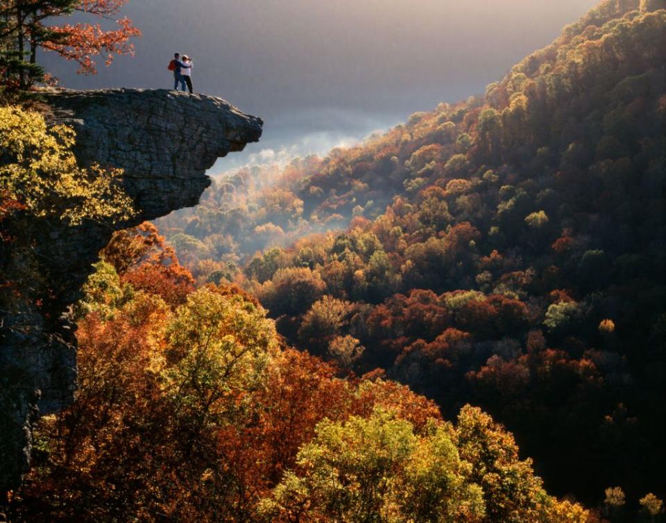 <p>Two hikers enjoy the view atop a cliff at Ozark National Forest near Boxley, Arkansas.</p>