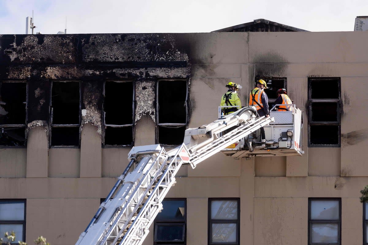 Firefighters inspect Loafers Lodge hostel  (AFP via Getty Images)