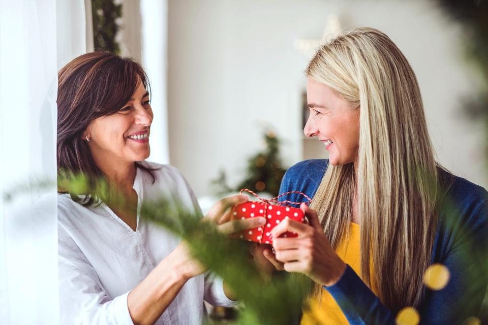 mother exchanging holiday gift with adult daughter