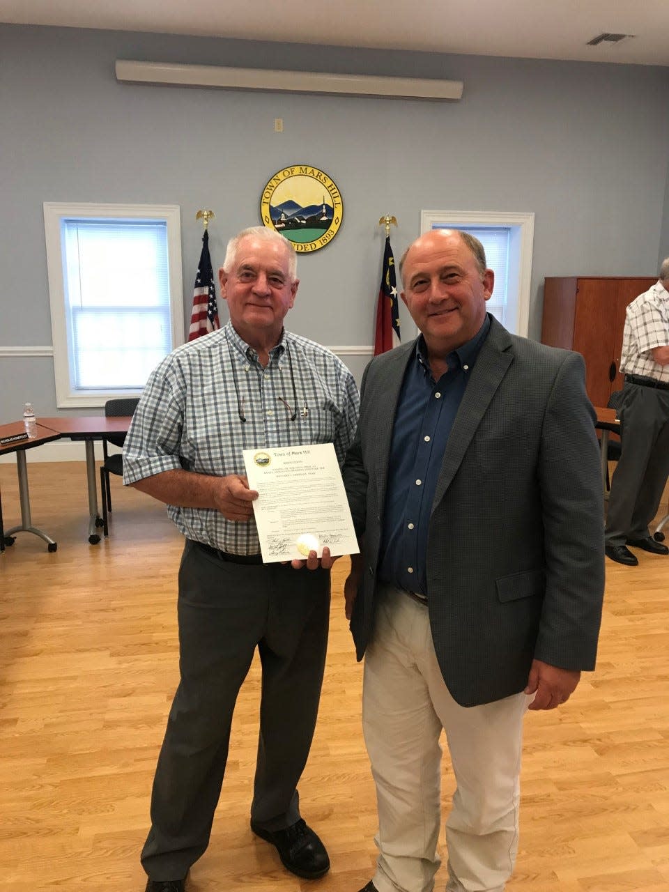 Mars Hill Mayor John Chandler poses with Richard L. Hoffman Executive Director Lee Hoffman during the Mars Hill Town Board's June 6 meeting, in which the board renamed the main trail at Bailey Mountain Preserve in honor of Richard Hoffman.