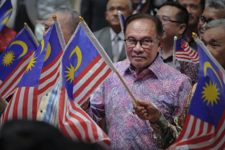 Malaysian Prime Minister Anwar Ibrahim waves national flag after deliver his speech for National Day at a convention centre in Putrajaya, Malaysia Wednesday, Aug. 30, 2023. Anwar made his first National Day address since taking over as Prime Minister in November last year. (AP Photo/Vincent Thian)