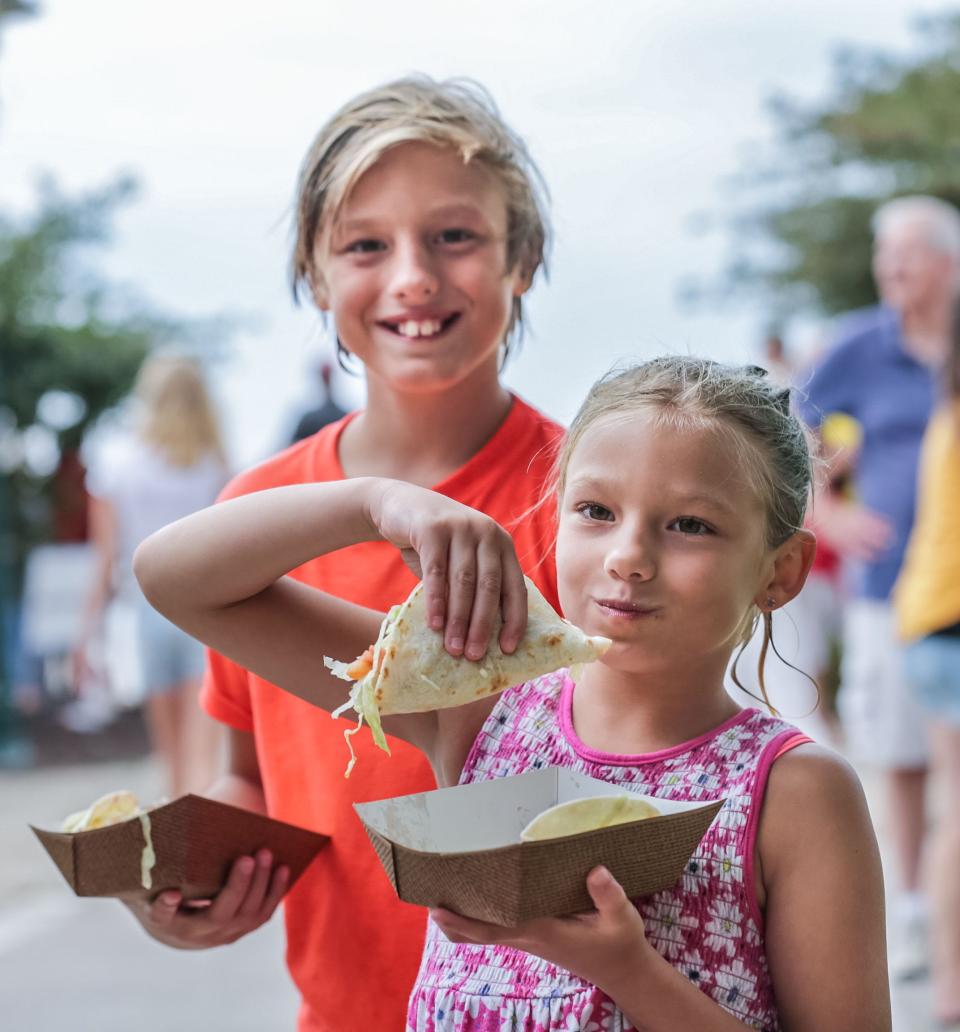 Ty Ladd, 10, and his sister Scout, 7, of Pewaukee, enjoy tacos from Casa Tequila during the 2019 North Shore Bank Taste of Lake Country at Pewaukee Beach. This year's Taste of Lake Country will be July 29 and 30.