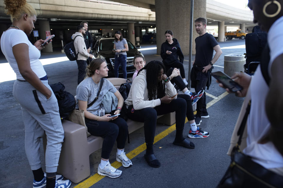 Players and staff of the New York Liberty WNBA basketball team wait to board buses at Harry Reid International Airport, Wednesday, June 28, 2023, in Las Vegas. The New York Liberty had a 13-hour travel day from Connecticut to Las Vegas during its recent three-game road trip, which required two bus rides, two commercial flights and a few hours in three airports. (AP Photo/John Locher)