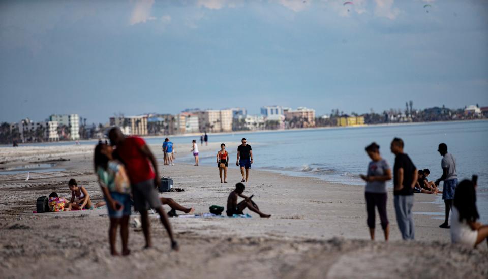 Visitors hang out on Fort Myers Beach  on Wednesday, Nov. 23, 2022.  The area was slammed by Hurricane Ian almost two months ago.  