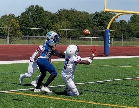 Hodgson's Marlon Sparks (3) makes a juggling interception in front of St. Georges receiver Jayson Askins-Brooks near the goal line with seven seconds remaining to preserve the Silver Eagles' 20-17 victory over the Hawks on Saturday.