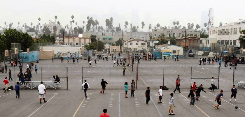 Children play on the blacktop at Berendo Middle School. A state grant would cover most of the cost of turning part of the playground into a green space, but the school district is balking at the required 20-year maintenance agreement.