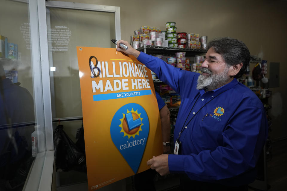Lottery official Jerry Cisneros puts up a sign inside the Las Palmitas Mini Market where the winning Powerball lottery ticket was sold in downtown Los Angeles, Thursday, July 20, 2023. The winning ticket for the Powerball jackpot is worth an estimated $1.08 billion and is the sixth largest in U.S. history and the third largest in the history of the game. (AP Photo/Marcio Jose Sanchez)