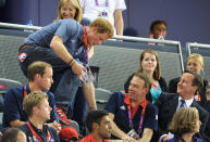 Prince Harry climbs over to his seat as Prince William; Duke of Cambridge (L) and Prime Minister David Cameron (R) look on his during Day 6 of the London 2012 Olympic Games at Velodrome on August 2, 2012 in London, England. (Photo by Pascal Le Segretain/Getty Images)