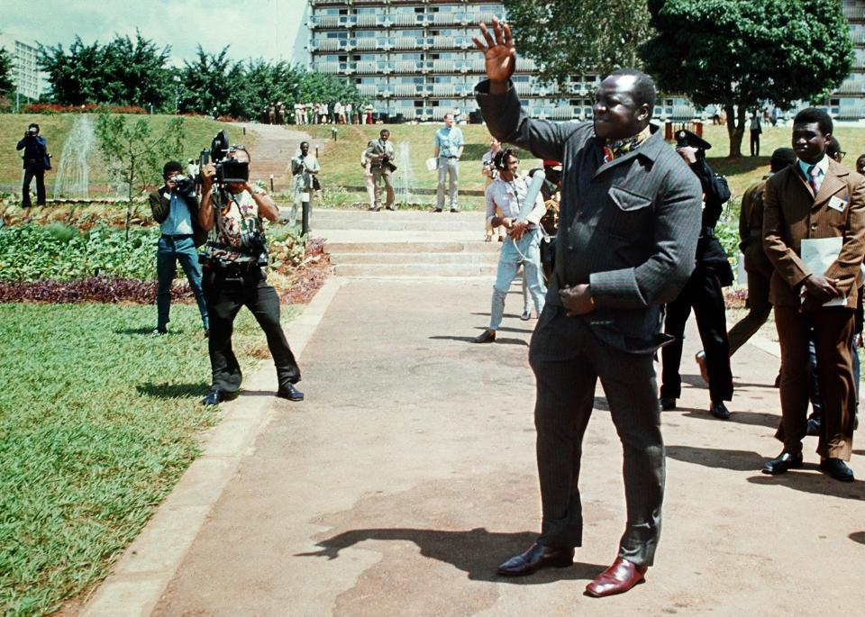 Idi Amin waves to the media during a summit in Kampala - AFP/Getty
