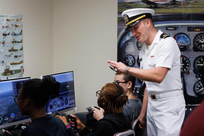 Ensign Lincoln Kilgore talks with students in flight simulators during the Aviation Summer Camp on Friday, June 24, 2022, at the Aviation Museum at Bluegrass Airport in Lexington, Kentucky.