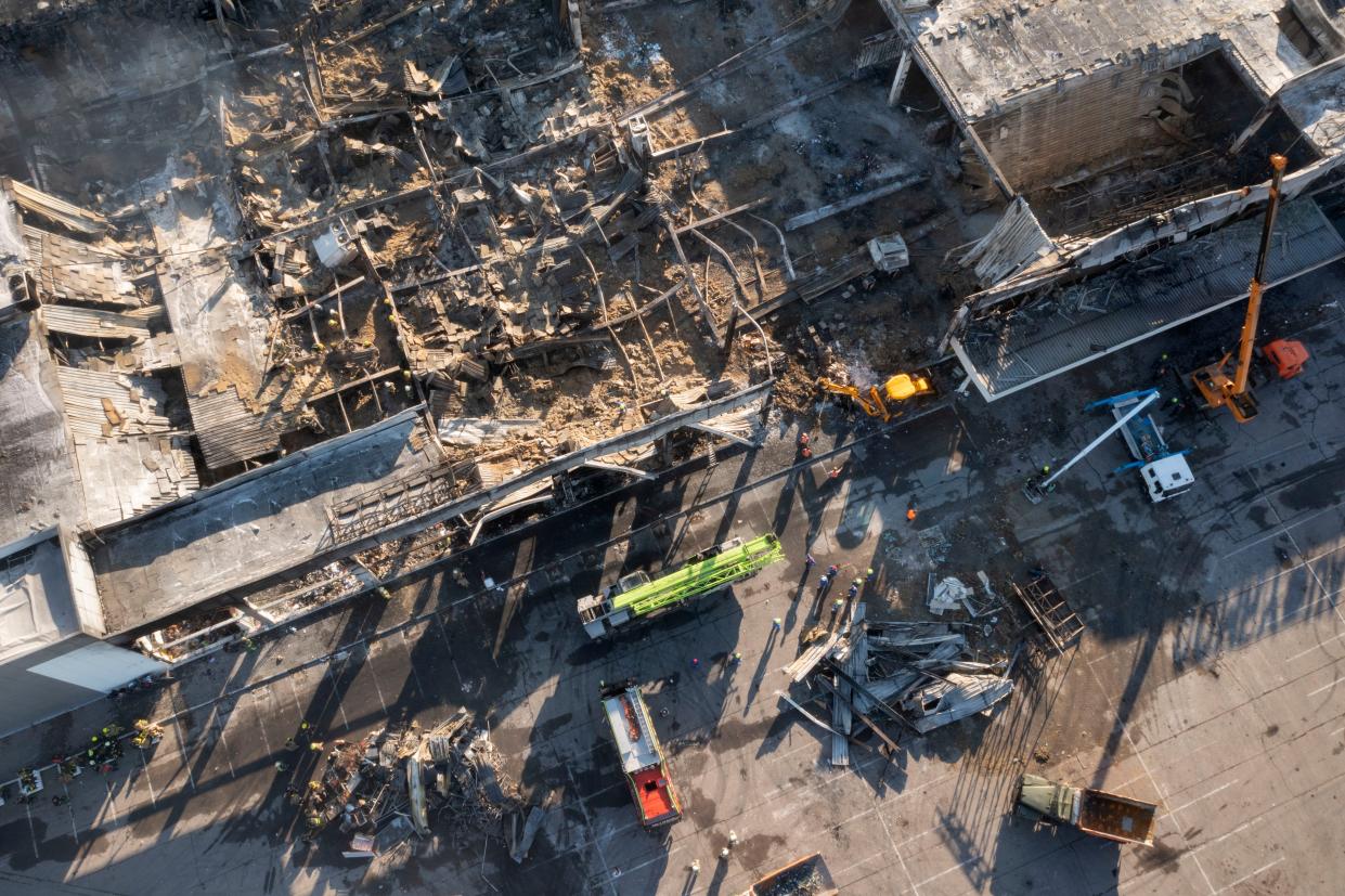 Ukrainian State Emergency Service firefighters work to take away debris at a shopping mall burned after a missile strike in Kremenchuk, Ukraine, Tuesday, June 28, 2022. 