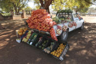 A car displays fruits and vegetables while selling them by the side of a busy road in Harare, Zimbabwe, Saturday, July, 4, 2020. Cars have become mobile markets in Zimbabwe where enterprising residents are selling goods from their vehicles to cope with economic hardships caused by the coronavirus. With their car doors and trunks wide open by the side of busy roads, eager sellers display a colorful array of goods in Harare, the capital. (AP Photo/Tsvangirayi Mukwazhi)