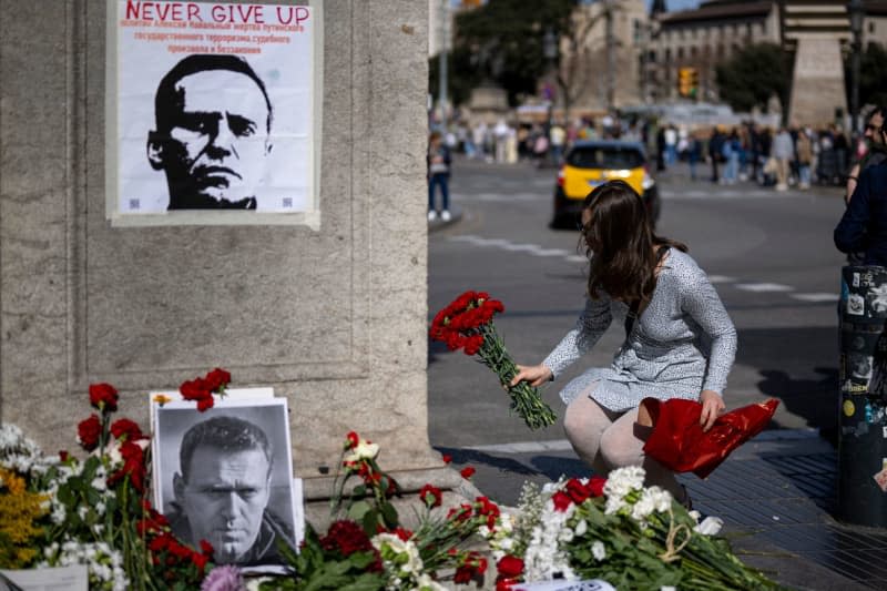 A woman puts flowers at a memorial improvised by Russian citizens for the death of Russian opposition figure Alexei Navalny on La Rambla Street in Barcelona. Lorena Sopêna/EUROPA PRESS/dpa