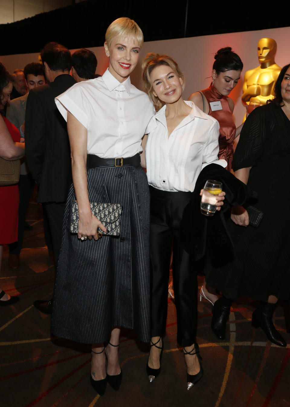 Charlize Theron, izquierda, y Renee Zellweger asisten al almuerzo de nominados a la 92ª entrega de los Premios de la Academia en el Hotel Loews el lunes 27 de enero de 2020 en Los Angeles. (Foto Danny Moloshok/Invision/AP)