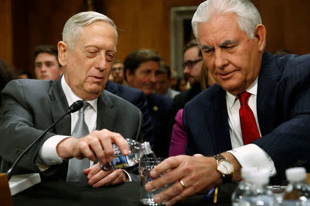 U.S. Defense Secretary James Mattis pours a glass of water for Secretary of State Rex Tillerson as they arrive to testify about authorizations for the use of military force before the Senate Foreign Relations Committee on Capitol Hill in Washington, U.S. October 30, 2017. REUTERS/Jonathan Ernst