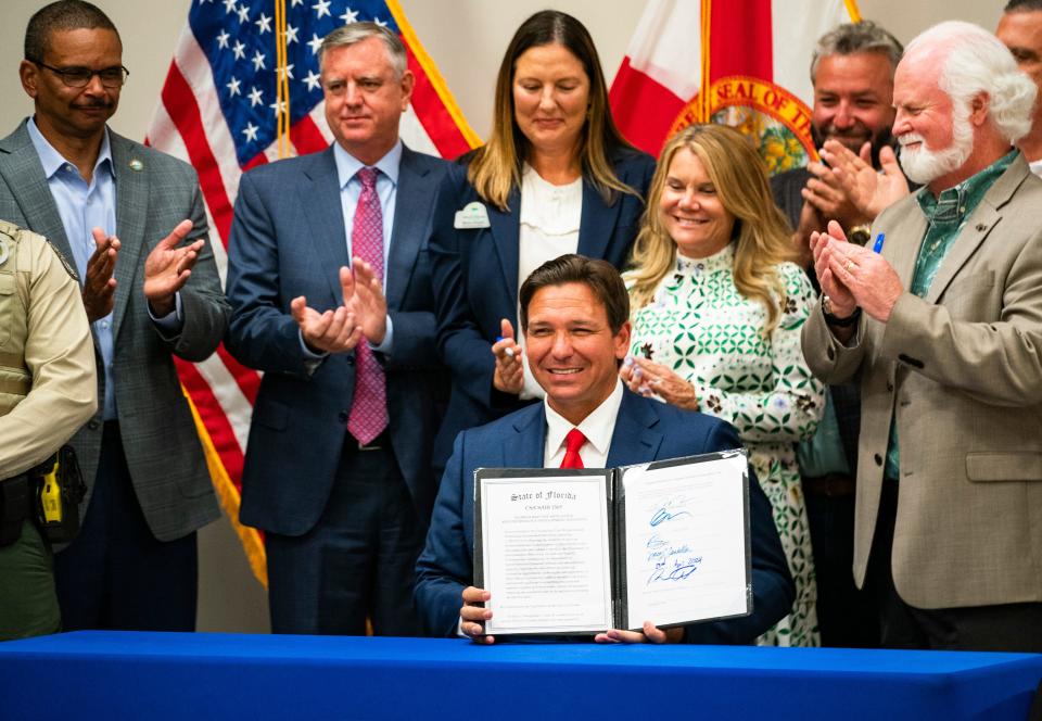 Gov. Ron DeSantis smiles after signing House Bill 1565 during a press conference at the FGCU Kapnick Education and Research Center in Naples on Tuesday, April 23, 2024. The bill aims to mitigate red tide as well as invest in more research about the harmful algal blooms.