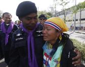 A riot police officer hugs an anti-government protester near the metropolitan police headquarters in Bangkok December 3, 2013. Thailand's government ordered police to stand down and allow protesters into state buildings on Tuesday, removing a flashpoint for clashes and effectively bringing an end to days of violence in Bangkok in which five people have died. REUTERS/Kerek Wongsa (THAILAND - Tags: POLITICS CIVIL UNREST)