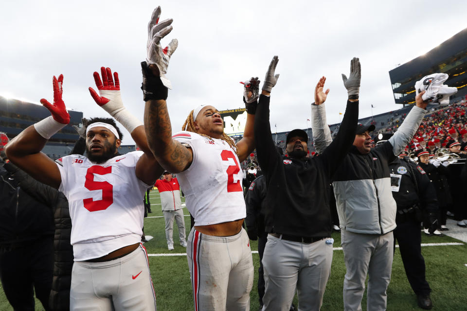 Ohio State's Baron Browning (5), Chase Young (2), linebackers coach Al Washington and head coach Ryan Day celebrate after a 56-27 win against Michigan after an NCAA college football game in Ann Arbor, Mich., Saturday, Nov. 30, 2019. (AP Photo/Paul Sancya)
