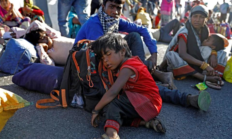 The daughter of a migrant worker sleeps on the road near India’s capital.