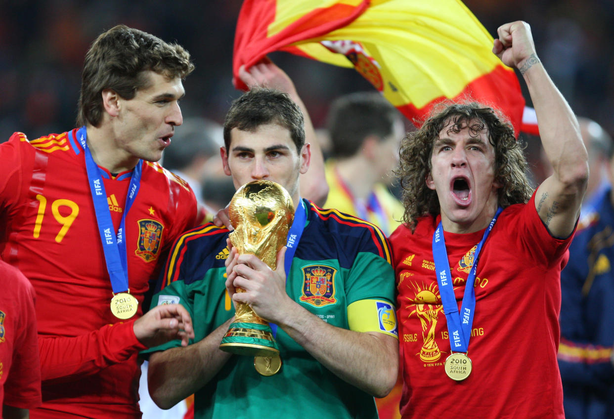 Iker Casillas of Spain kisses the FIFA World Cup Trophy as he celebrates Spain becoming the 2010 FIFA World Cup Champions with Fernando Llorente and Carles Puyol of Spain (Photo by AMA/Corbis via Getty Images)