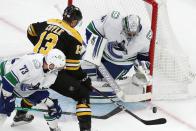 Vancouver Canucks' Jaroslav Halak (41) blocks a shot by Boston Bruins' Charlie Coyle (13) during the first period of an NHL hockey game, Sunday, Nov. 28, 2021, in Boston. (AP Photo/Michael Dwyer)