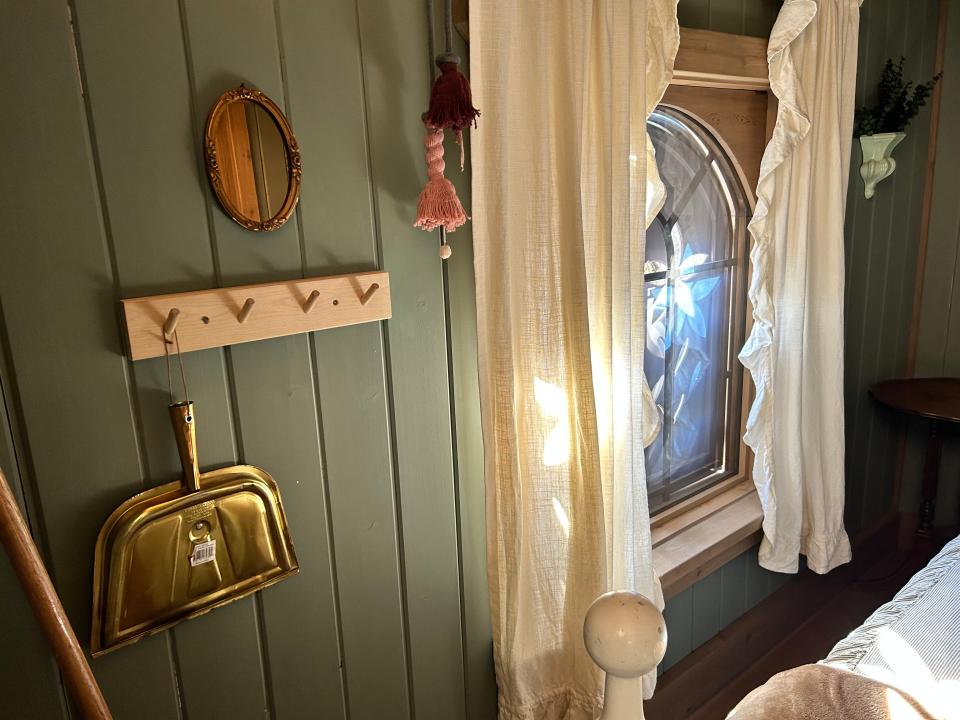 HOOKS on wall and curtain next to main bed in Rapunzel's Cottage