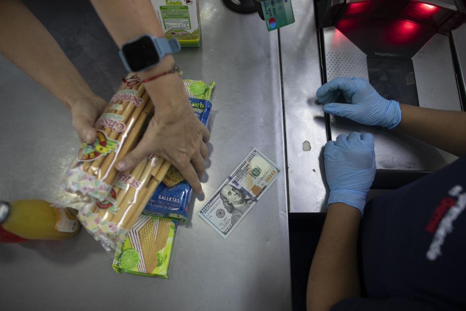 A shopper checks out at a supermarket in Caracas, Venezuela, Friday, June 4, 2021. Two years ago Venezuela stopped restricting transactions in dollars, which has largely ended shortages but has meant many Venezuelans who are paid in bolivars can't afford what's on those shelves. ( AP Photo/Ariana Cubillos)