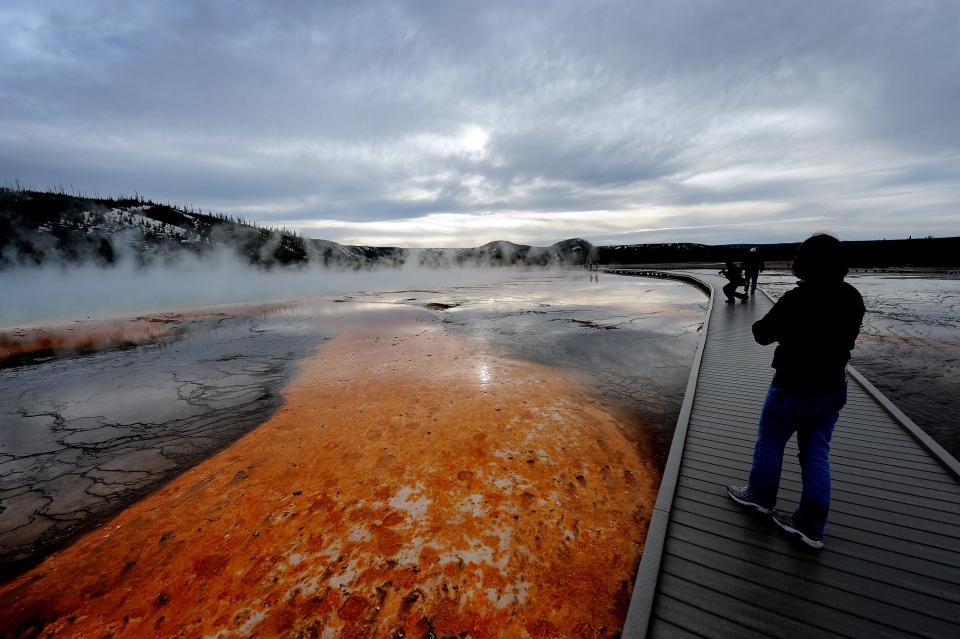 View of the 'Grand Prismatic' hot spring with it's unique colors caused by brown, orange and yellow algae-like bacteria called Thermophiles, that thrive in the cooling water turning the vivid aqua-blue to a murkier greenish brown, in the Yellowstone National Park, Wyoming on June 1, 2011.  Yellowstone National Park, was established by the U.S. Congress and signed into law by President Grant on March 1, 1872. The park is located primarily in the U.S. state of Wyoming, though it also extends into Montana and Idaho and was the first national park in the world. It is known for its wildlife and its many geothermal features, especially the Old Faithful Geyser.        AFP PHOTO/Mark RALSTON (Photo credit should read MARK RALSTON/AFP/Getty Images) [Via MerlinFTP Drop]