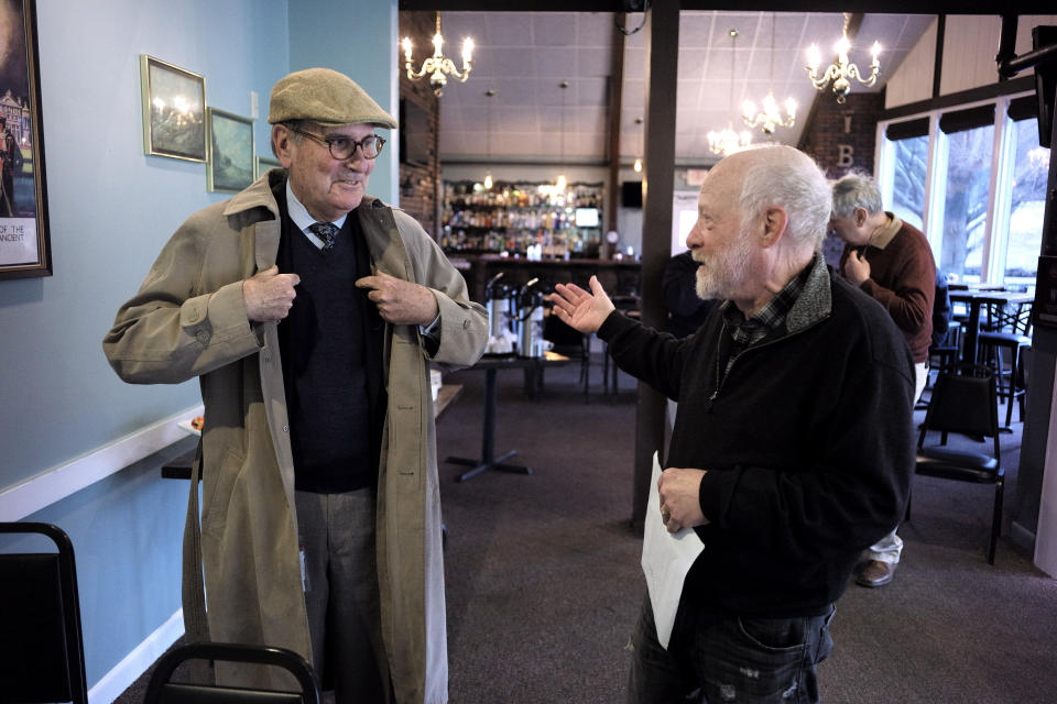 In this Wednesday, April 10, 2019 photo President of The Berkshire Eagle newspaper Fred Rutberg, left, speaks with Lanny Lambert, of Pittsfield, Mass., right, at the conclusion of a "coffee with the president of the Berkshire Eagle" gathering, in Williamstown, Mass. The paper now features a new 12-page lifestyle section for Sunday editions, a reconstituted editorial board, a new monthly magazine, and the newspaper print edition is wider. That level of expansion is stunning in an era where U.S. newspaper newsroom employment has shrunk by nearly half over the past 15 years. (AP Photo/Steven Senne)